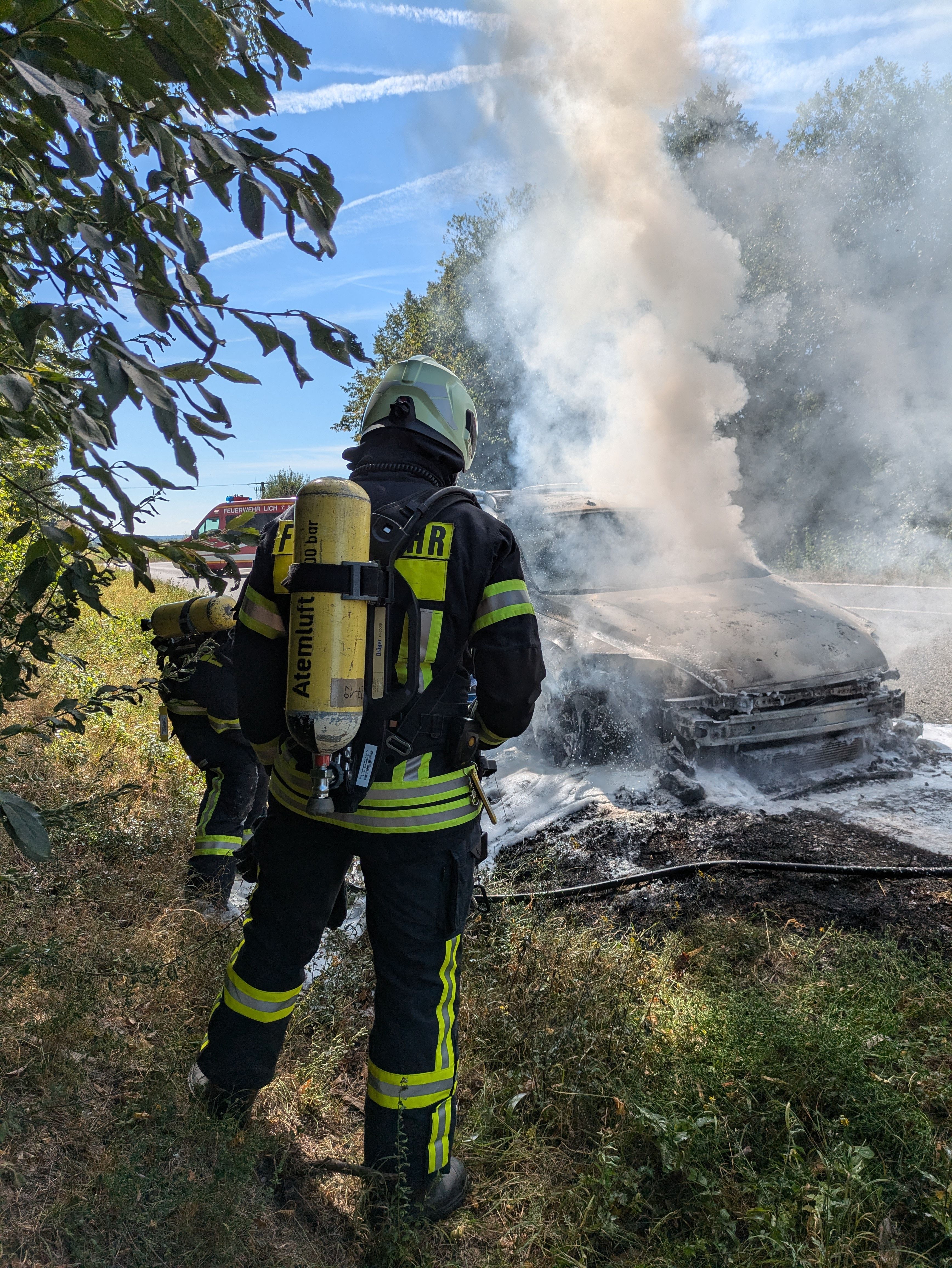 Feuerwehrmann vor brennendem Auto